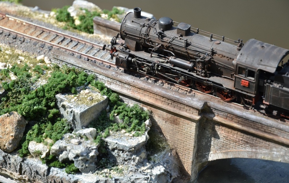 H0-Dampflokomotive auf einer erhöhten Modellbahnstrecke