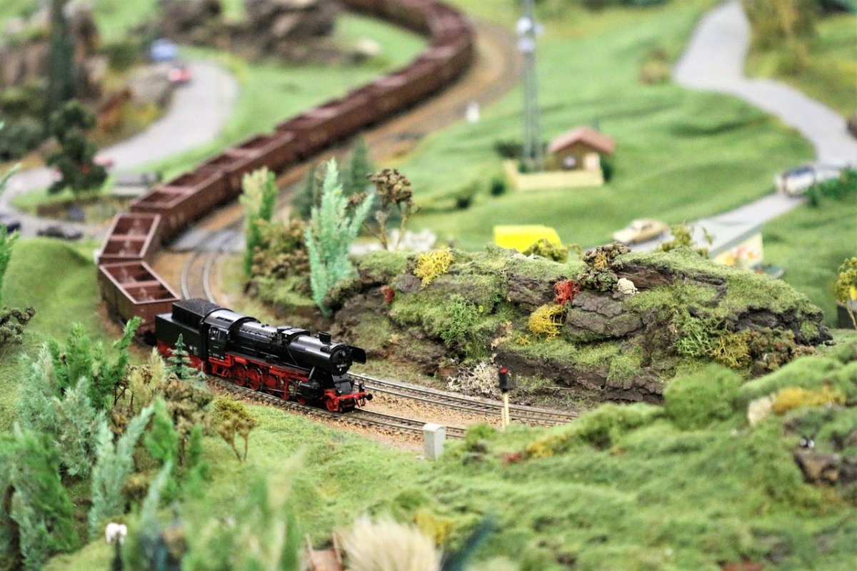 H0-Modellbahnlandschaft mit Dampflok und bewachsenen Hügeln