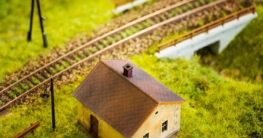 Modellbahnanlage mit Gleisen, Gebäuden und Landschaft