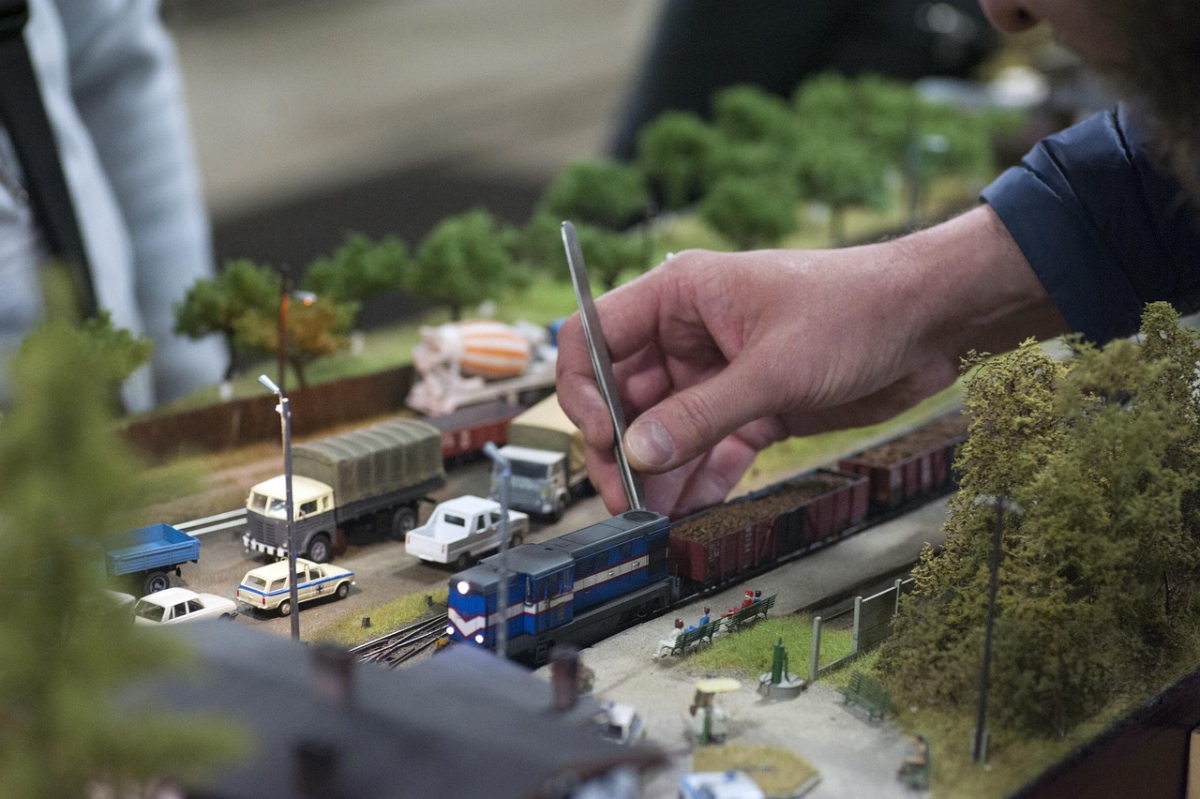 Modellbahnhof mit Lokomotive, Bahnsteig und Figuren
