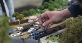 Modellbahnhof mit Lokomotive, Bahnsteig und Figuren